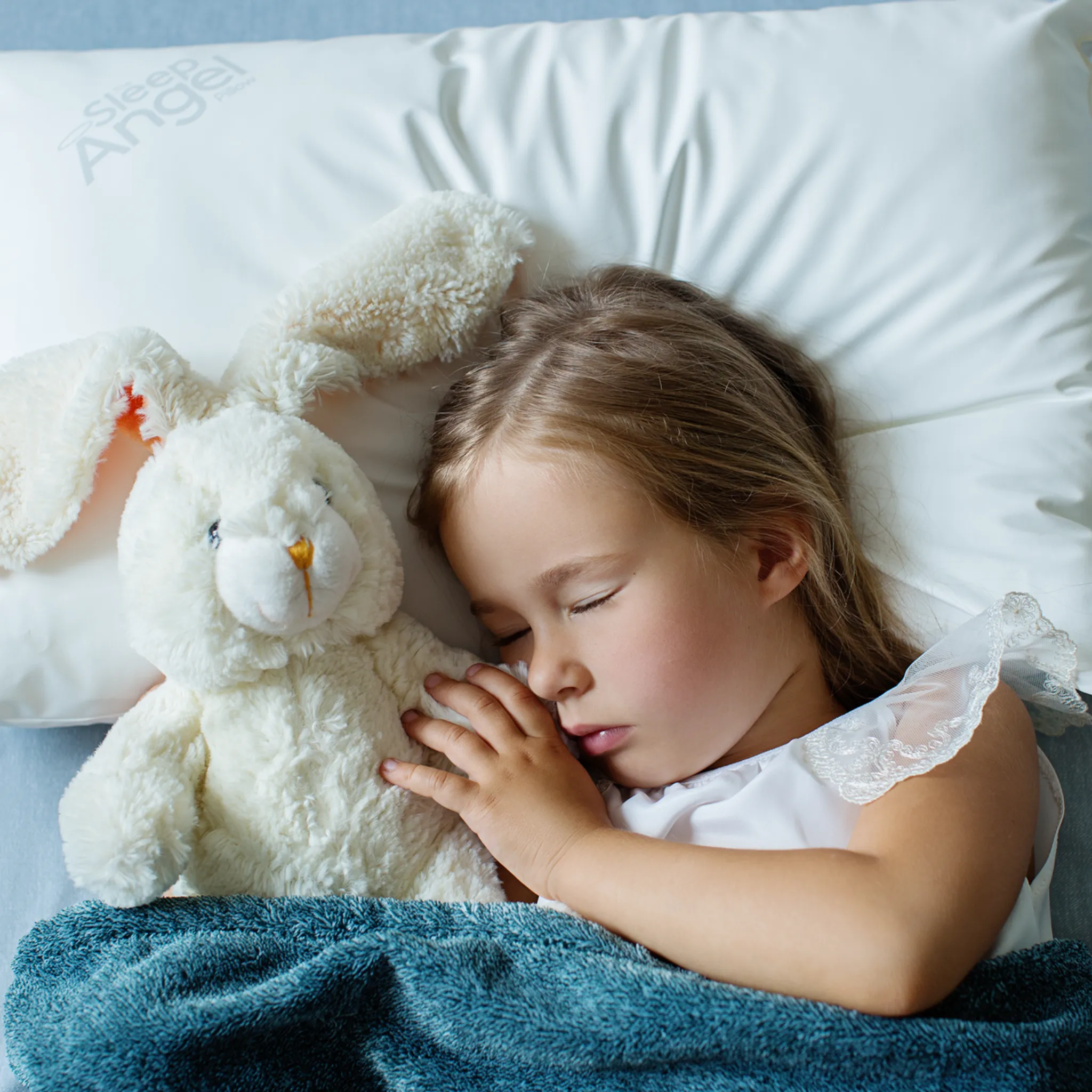 Child asleep on SleepAngel pillow with plush toy – Shopify lifestyle foto